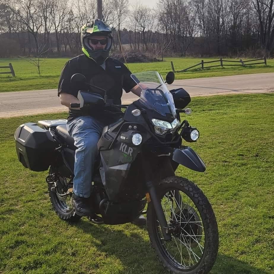 Rider sitting on a Kawasaki KLR adventure motorcycle